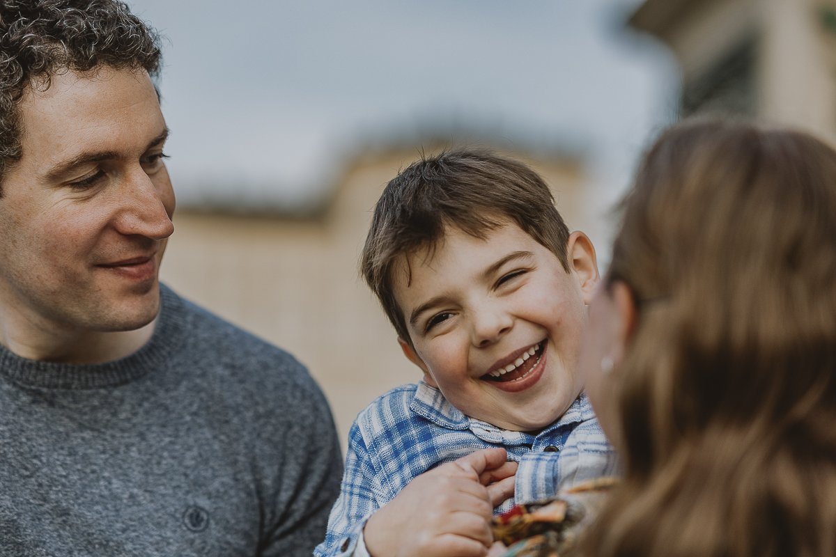 Servizio fotografico per famiglia americana in vacanza a Torino. Il piccolo caleb ride abbracciato dai genitori