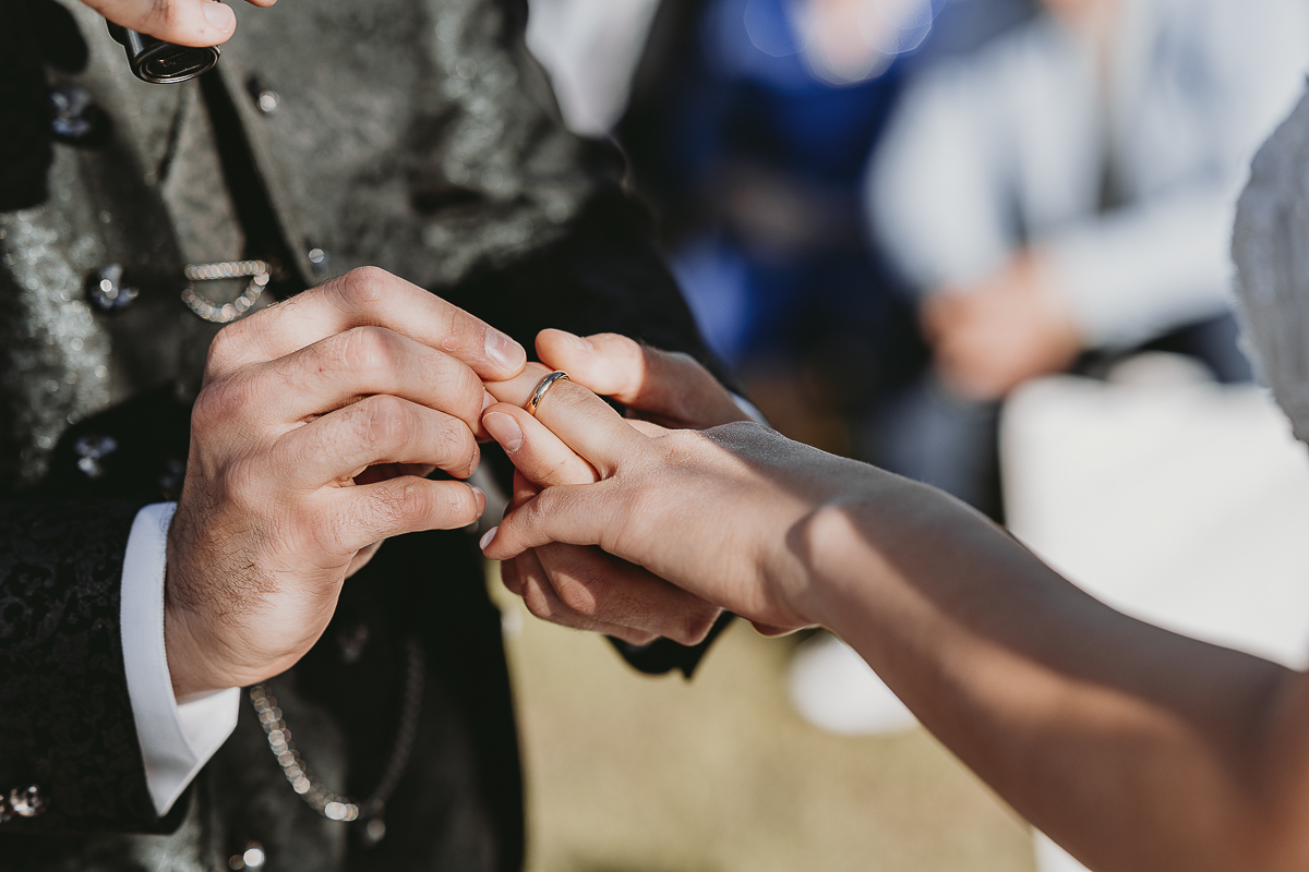 Matrimonio Lago di Candia. Cerimonia. Scambio degli anelli. Sposo mette la fede al dito della sposa.