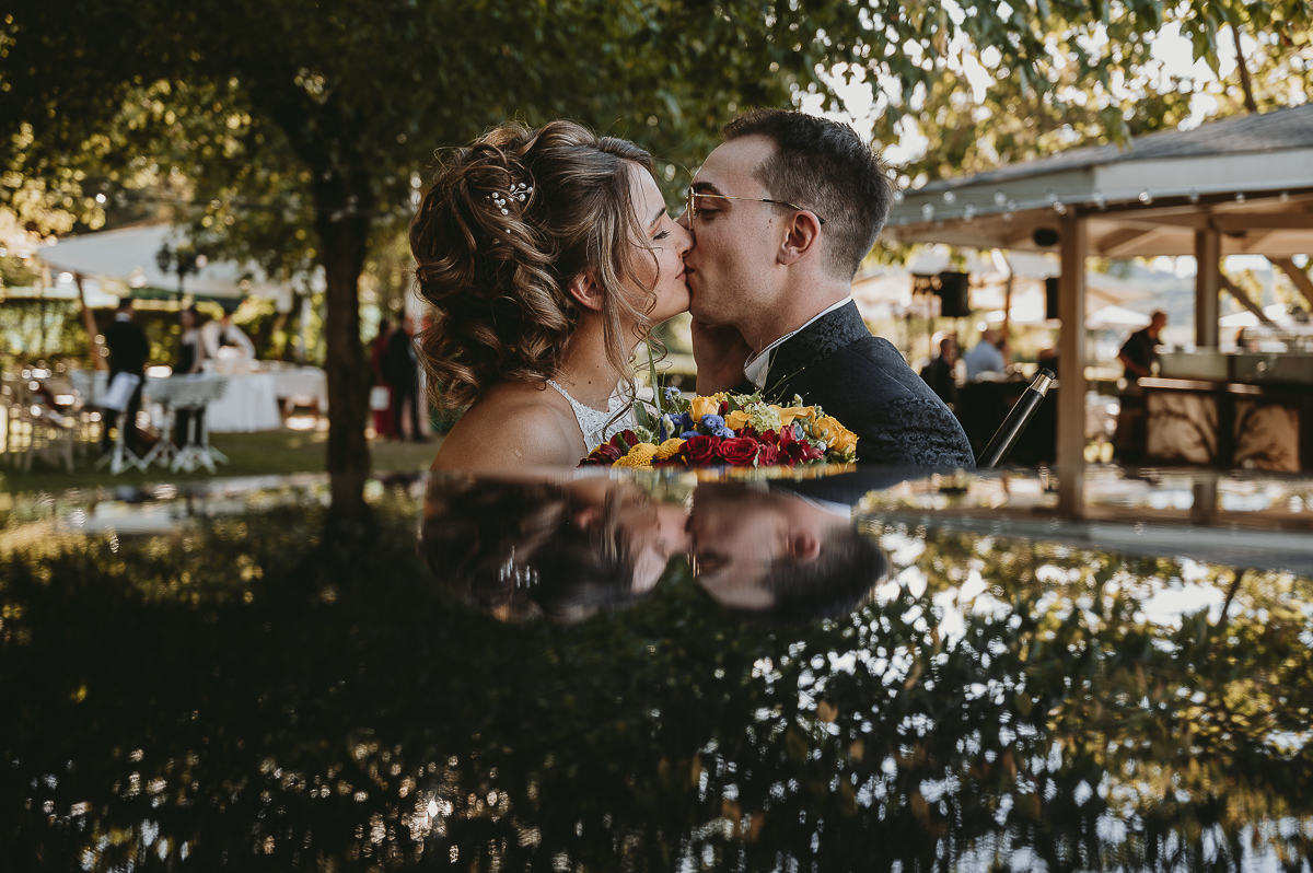 Matrimonio Lago di Candia. Fotografia di coppia.Sposi si baciano riflessi nell'auto d'epoca.