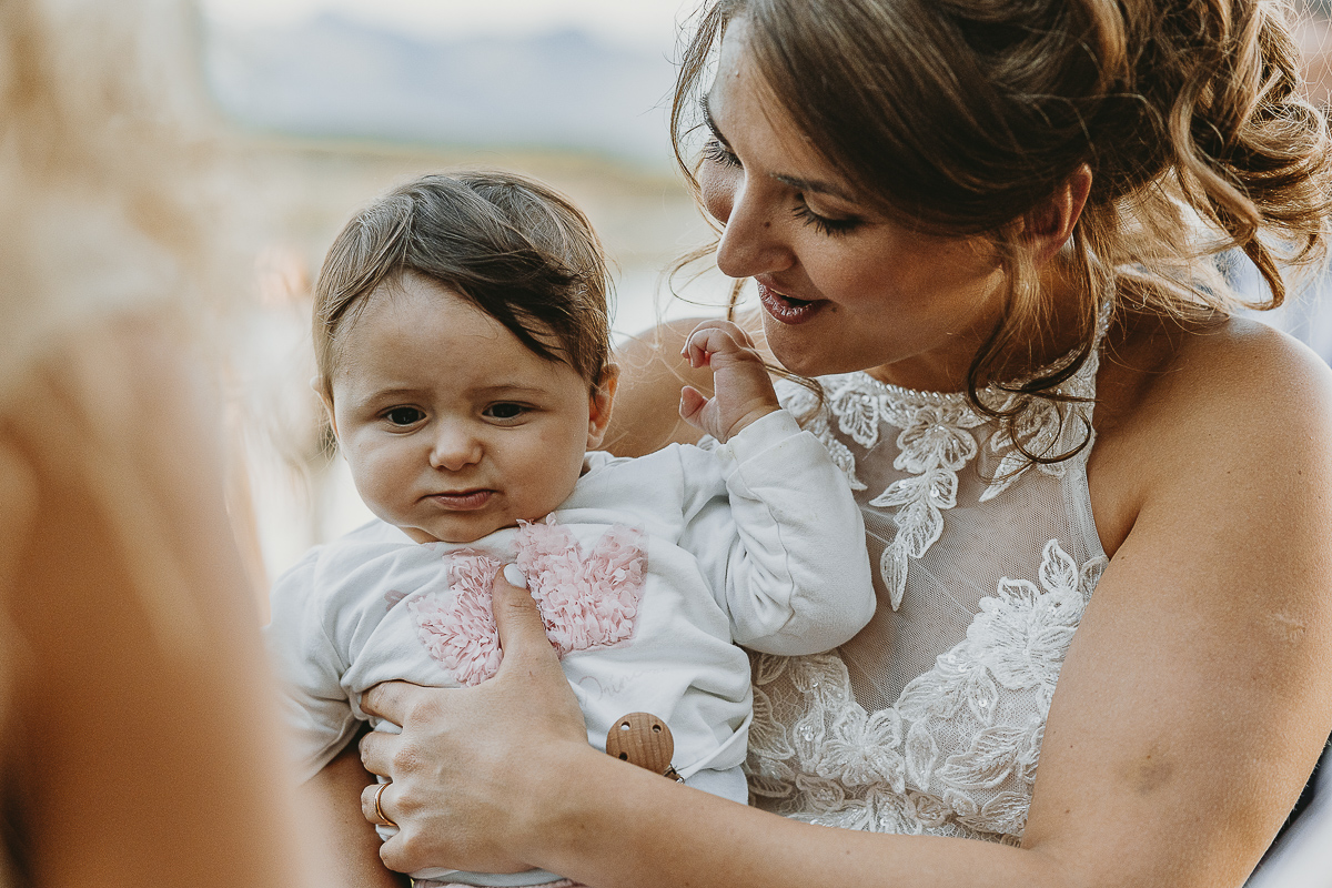 Matrimonio Lago di Candia. Aperitivo. Sposa tiene in braccio una bambina.