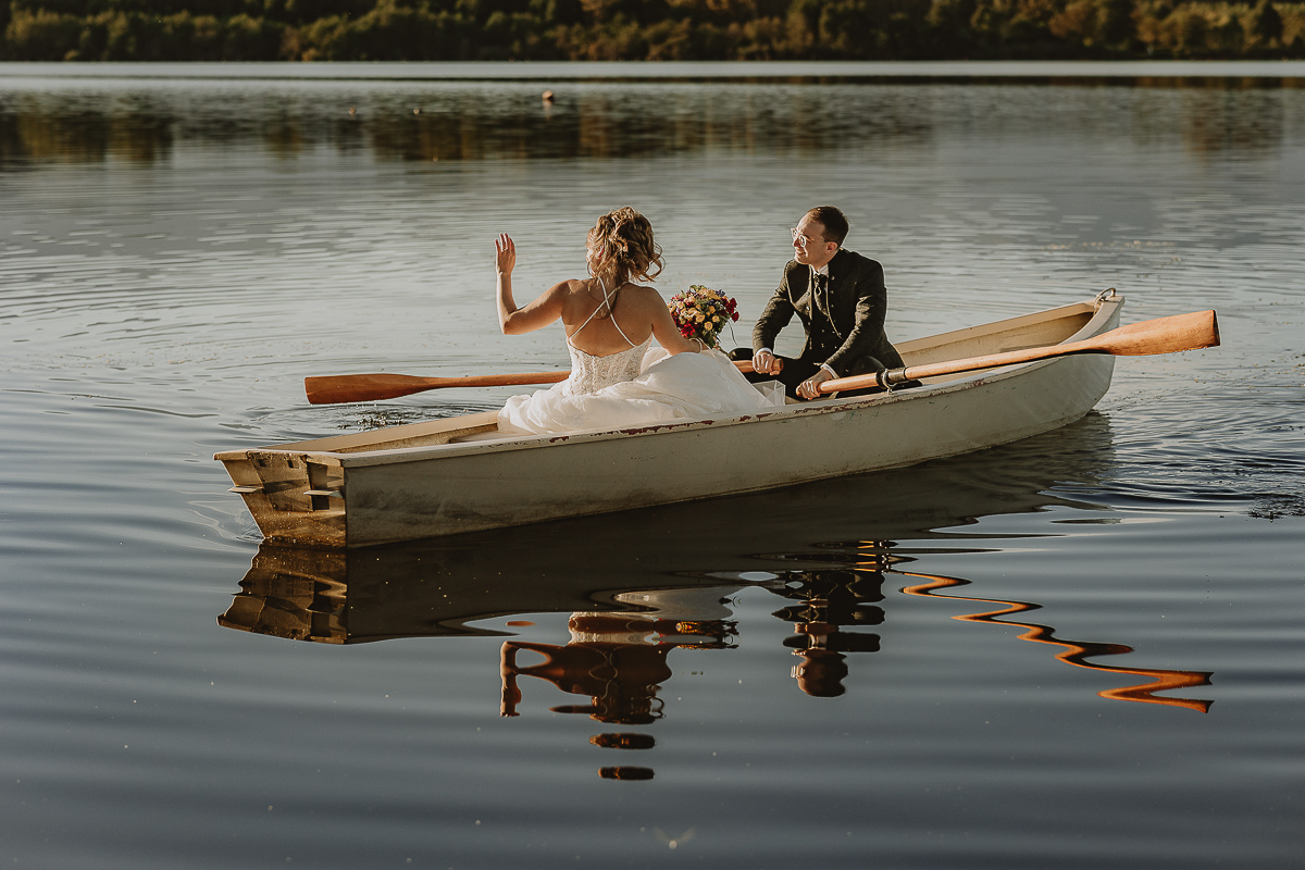 Matrimonio Lago di Candia. Ritratti di coppia. Sposi sulla barca a remi. La sposa saluta.
