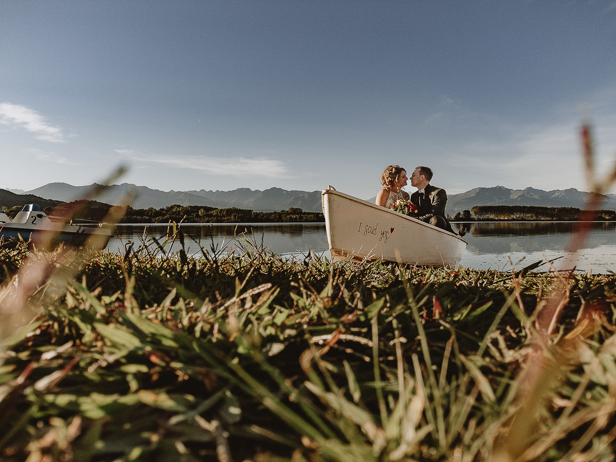 Matrimonio Lago di Candia. Ritratti di coppia. Sposi sulla barca a remi a riva. Foto da drone sul terreno.