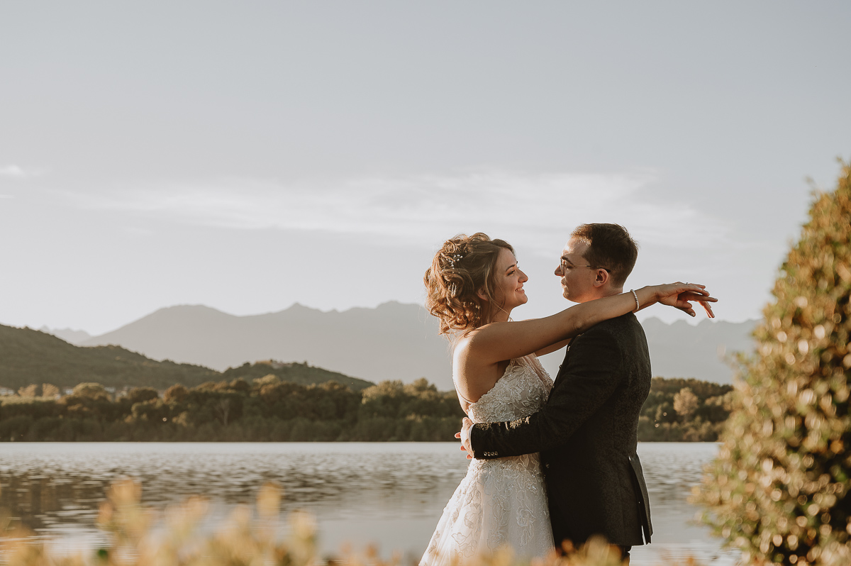 Matrimonio Lago di Candia. Ritratti di coppia. La sposa mette le braccia al collo dello sposo.