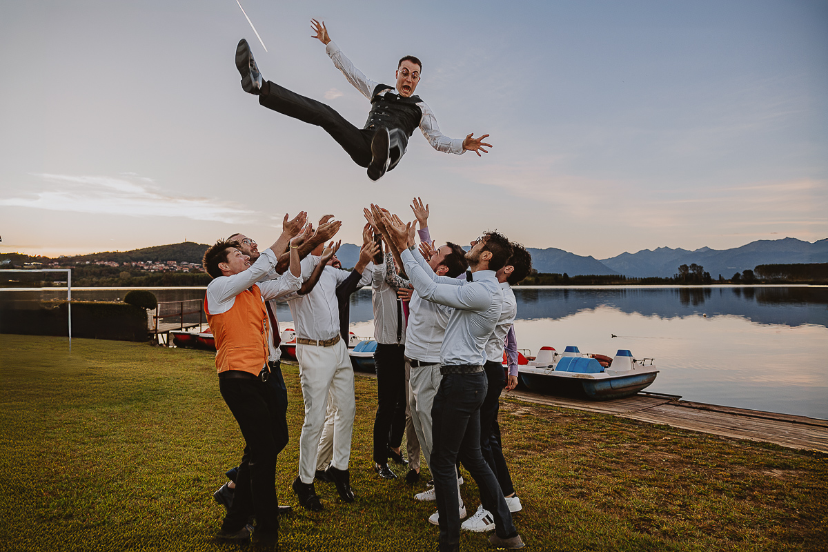 Matrimonio Lago di Candia. Festa. Amici fanno volare lo sposo.