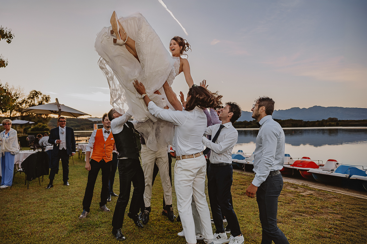 Matrimonio Lago di Candia. Festa. Amici fanno volare la sposa.