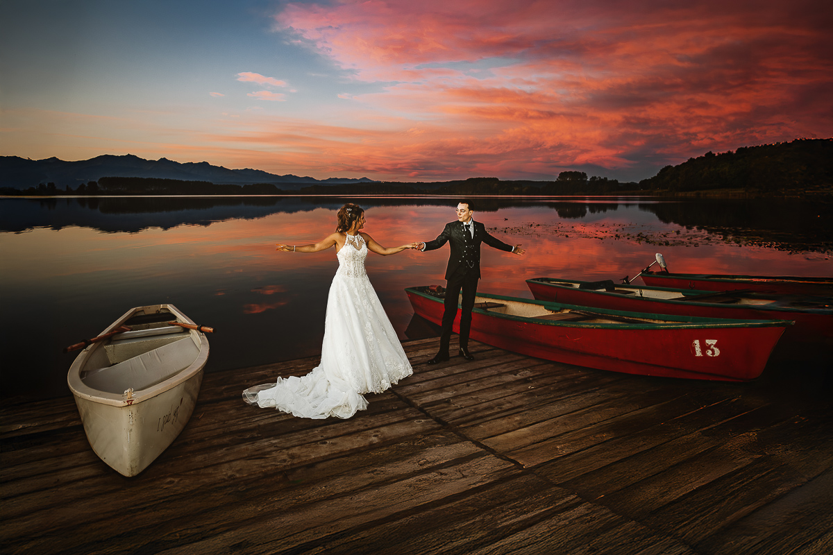 Matrimonio Lago di Candia. Festa. Ritratti di coppia con uno splendido tramonto. Sposi si prendono per mano.