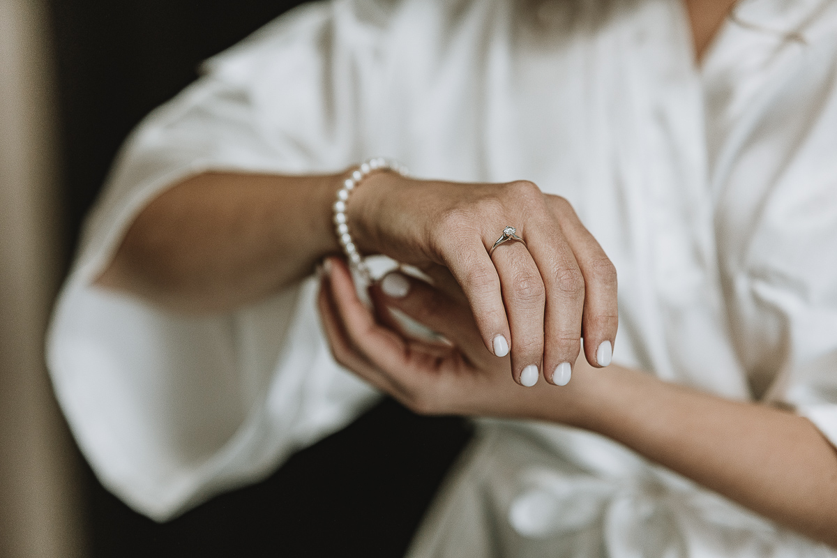 Matrimonio Lago di Candia . Preparazione della sposa. Sposa si mette il braccialetto.
