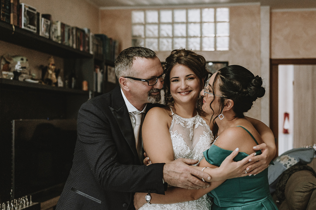 Matrimonio Lago di Candia . Preparazione della sposa. Sposa con i suoi genitori abbracciati.