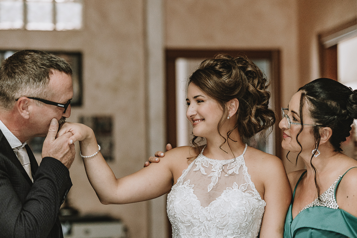 Matrimonio Lago di Candia . Preparazione della sposa. Padre bacia la mano della sposa e madre li guarda.