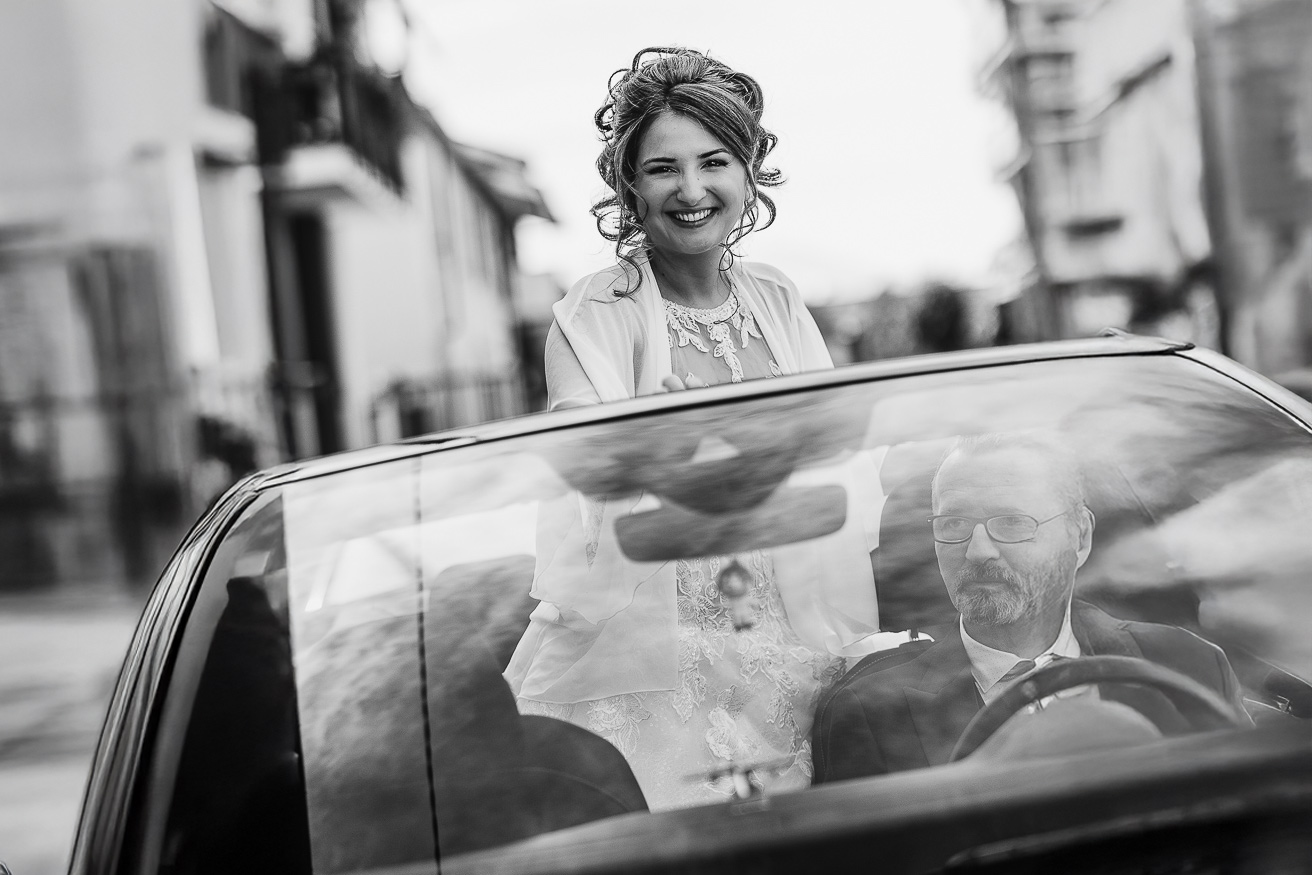 Matrimonio Lago di Candia . Preparazione della sposa. Sposa in auto con il padre che guida. in bianco e nero.