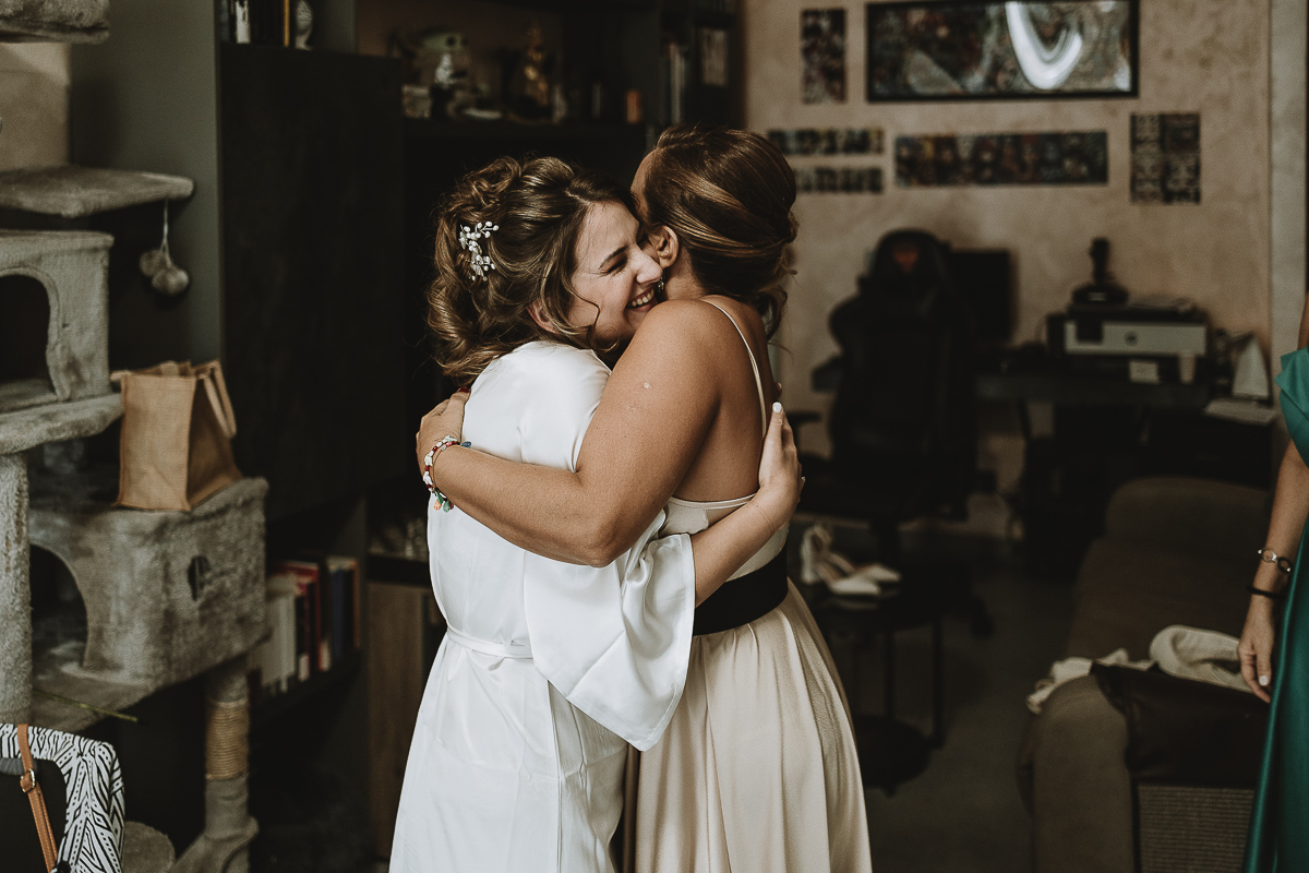 Matrimonio Lago di Candia preparazione della sposa. Sposa abbraccia la cugina.