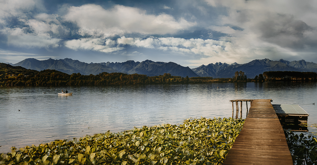 Matrimonio Lago di Candia. Cerimonia. Sposa sulla barca a remi . Panoramica dal pontile.