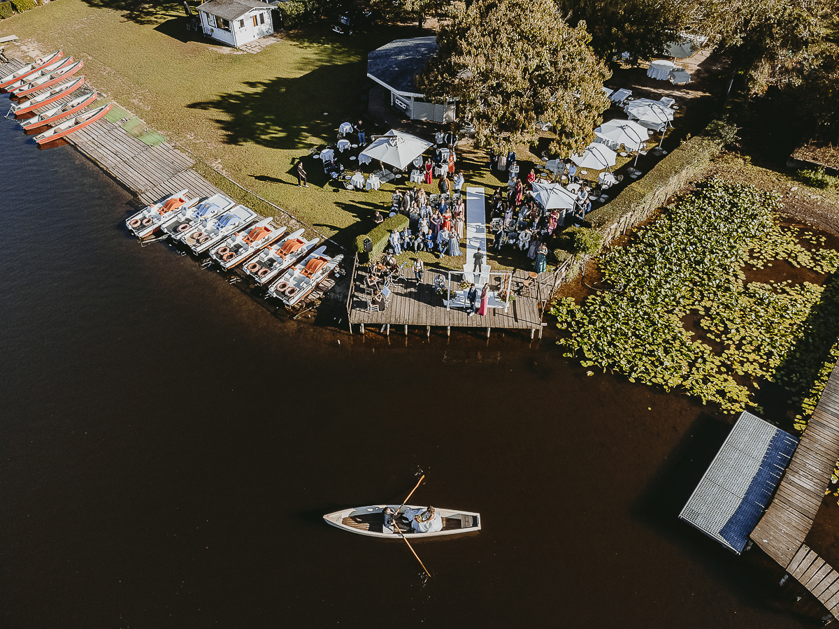 Matrimonio Lago di Candia. Cerimonia. Sposa sulla barca a remi e luogo della cerimania sul molo. Foto aerea dal drone.