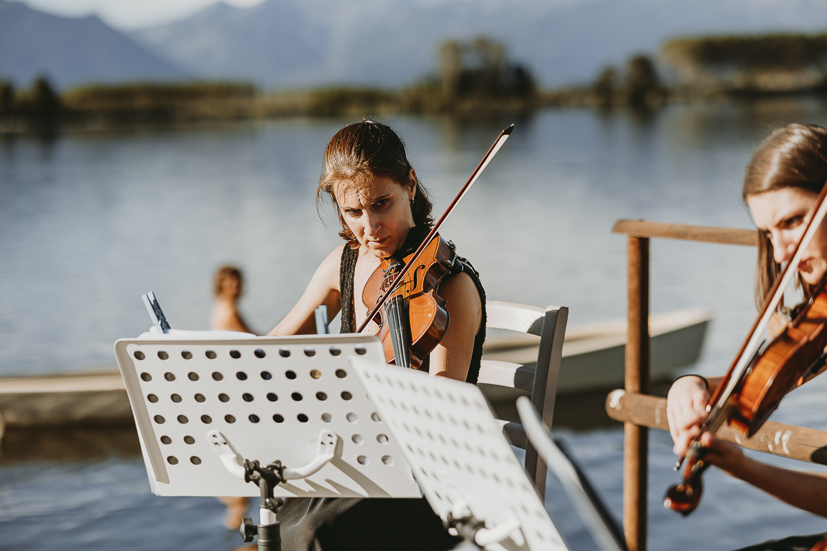 Matrimonio Lago di Candia. Cerimonia. Sposa sulla barca a remi Violiniste suonano.