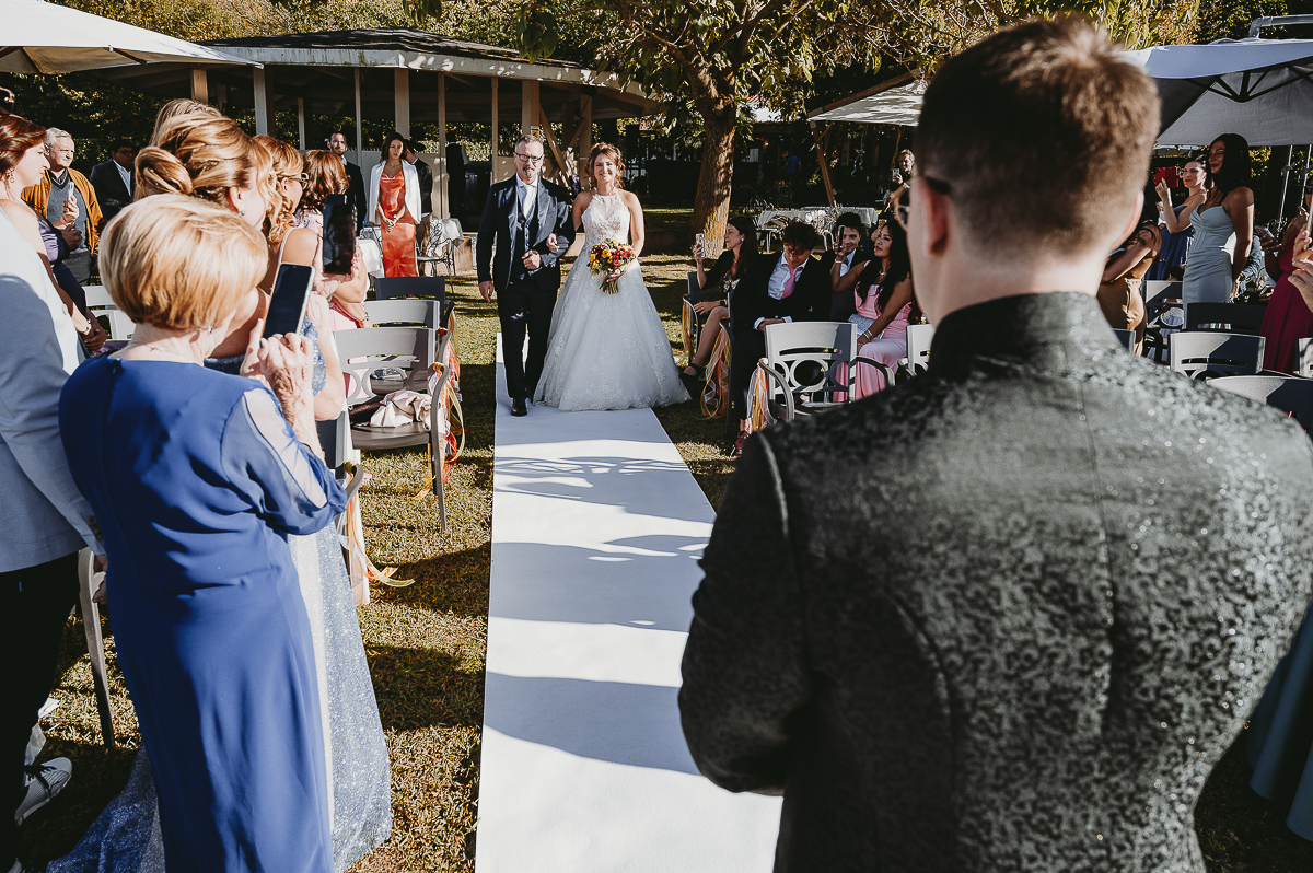 Matrimonio Lago di Candia. Cerimonia. Sposa fa l'ingresso nel luogo della cerimonia sul molo mentre lo sposo aspetta.
