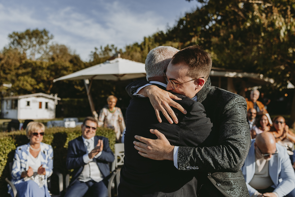Matrimonio Lago di Candia. Cerimonia. Sposo abbraccia il nonno.