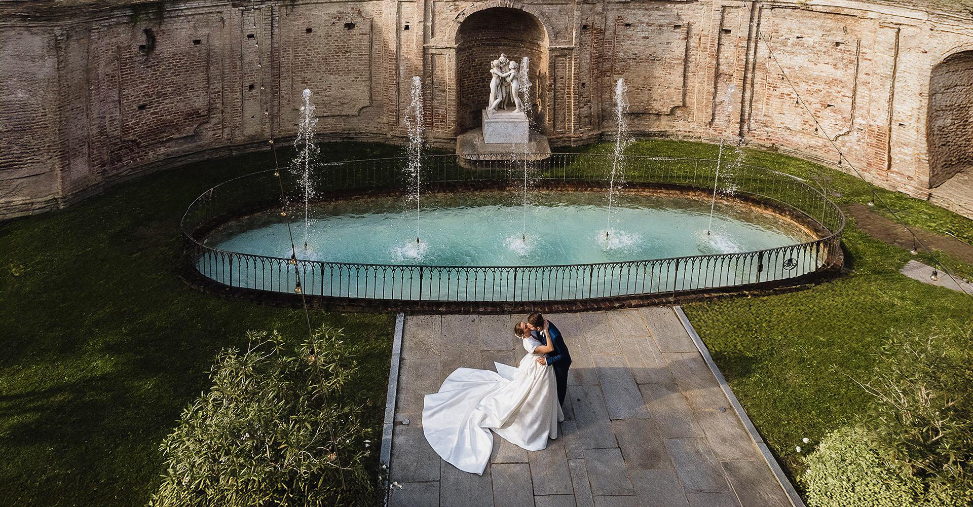 matrimonio luxury a Villa Bria con sposi in posa romantica davanti alla fontana. Foto aerea dal drone