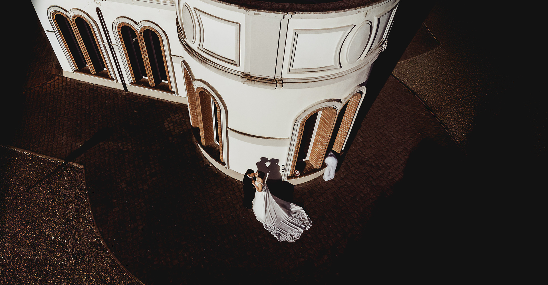 Fotografo di reportage di matrimonio a Torino. Fotografia aerea degli sposi con gioco di luci ed ombre al Principe rosso di valmadonna