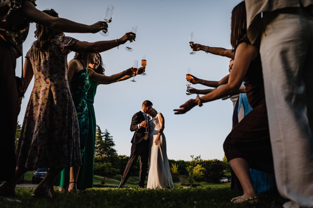 都灵婚礼摄影 – 与朋友们举杯时的新婚之吻