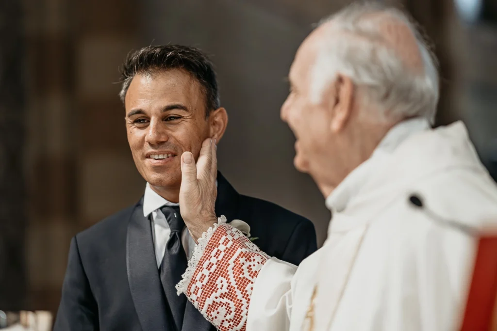 婚礼纪实摄影 – 神父在仪式中以充满感情的动作轻抚新郎