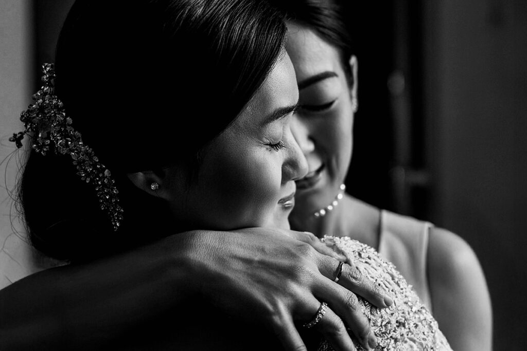 Scegliere il fotografo di matrimonio - abbraccio emozionante tra la sposa e la sorella durante i preparativi