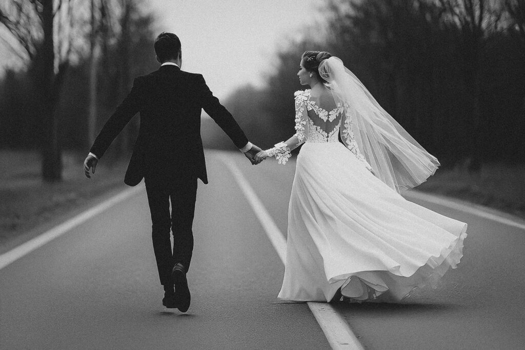 Sposi che camminano mano nella mano lungo una strada, immagine dinamica ed elegante per l’articolo sugli sposi che non rispondono