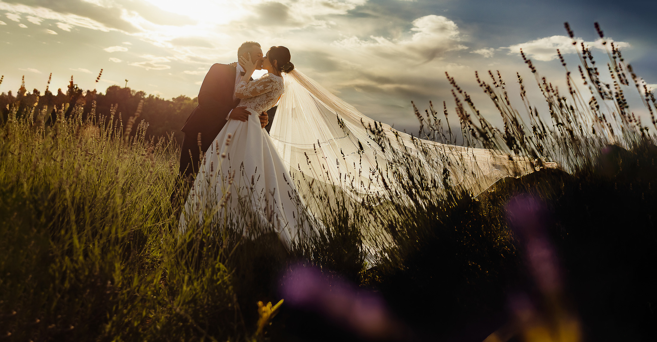"fotografo matrimonio Giardini La Pergola – sposi che si baciano al tramonto tra la lavanda"