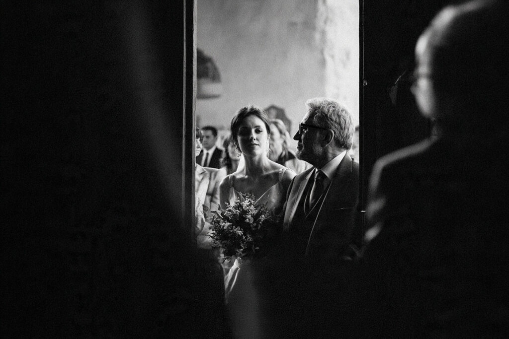 valore della fotografia di matrimonio, la sposa entra in chiesa con il padre in un momento intenso e senza tempo