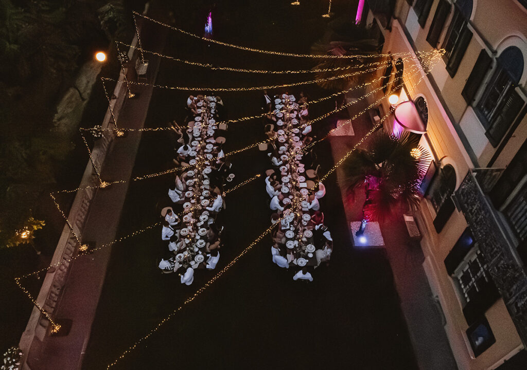 Cena serale di matrimonio alla Cedrina con luci sospese e tavoli imperiali nel giardino della villa. Foto da drone