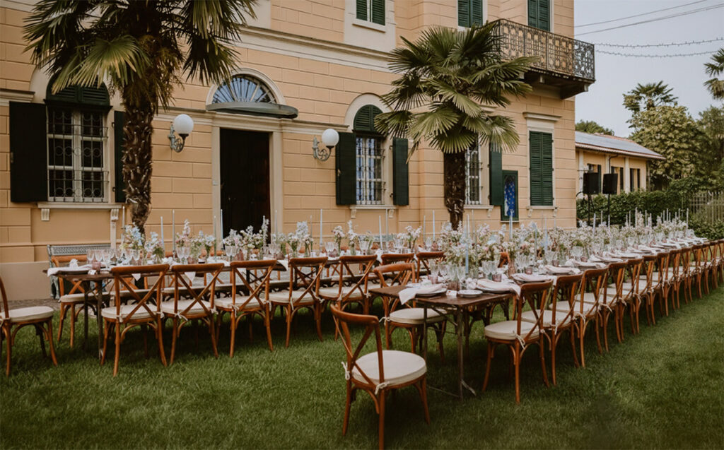 Tavolo imperiale per matrimonio alla Cedrina allestito nel parco della villa con fiori, candele e sedute in legno