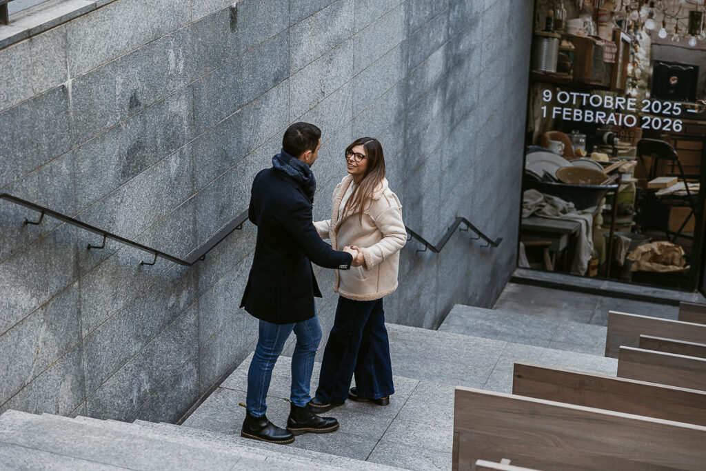 Coppia durante un prewedding natalizio a Torino, fotografia dall’alto con geometrie di scale e panchine