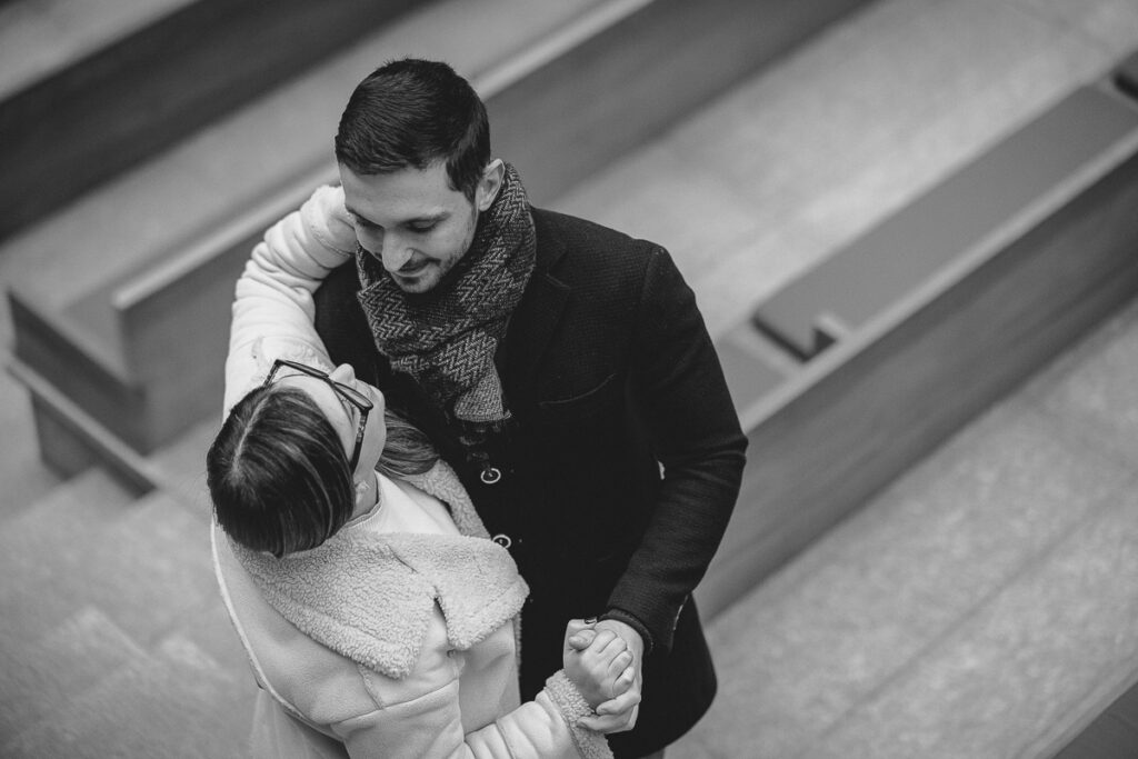 Prewedding natalizio a Torino, coppia vista dall’alto tra scale e panchine con struttura grafica urbana