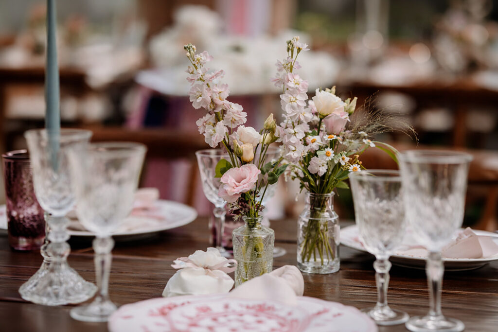 Dettaglio del centrotavola floreale di un matrimonio alla Cedrina con fiori delicati e bicchieri in vetro lavorato