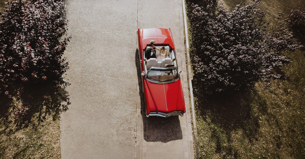 Matrimonio a Tigliole d’Asti arrivo degli sposi in Cadillac rossa visto dall’alto